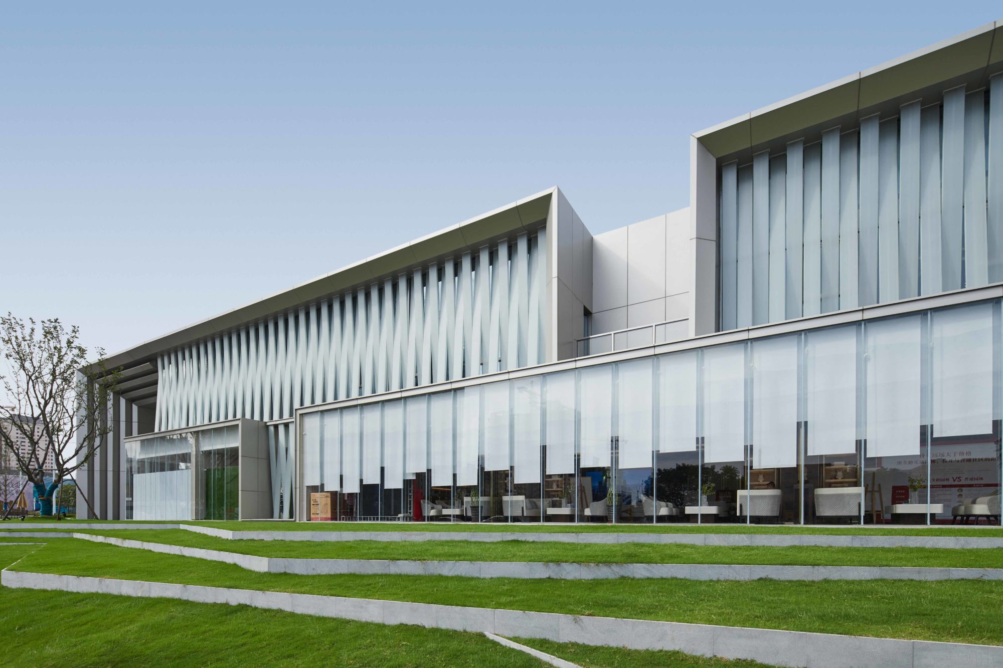 建筑在沿街的一侧插入两个透明的玻璃体块,在建筑内部展示出城市的一